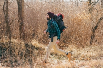 cool-hipster-man-traveling-with-backpack-autumn-forest-wearing-checkered-shirt-hat_285396-9736