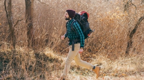 cool-hipster-man-traveling-with-backpack-autumn-forest-wearing-checkered-shirt-hat_285396-9736