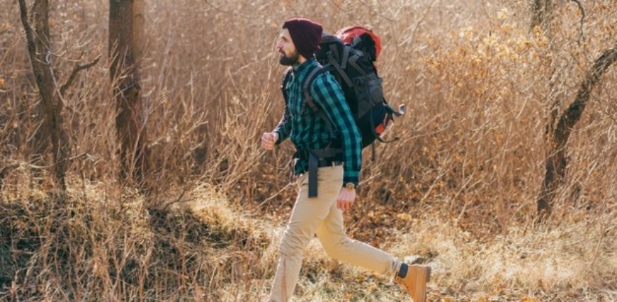 cool-hipster-man-traveling-with-backpack-autumn-forest-wearing-checkered-shirt-hat_285396-9736