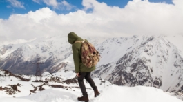 young-hipster-man-hiking-mountains-winter-vacation-traveling_285396-1951