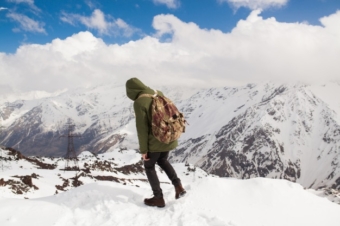 young-hipster-man-hiking-mountains-winter-vacation-traveling_285396-1951