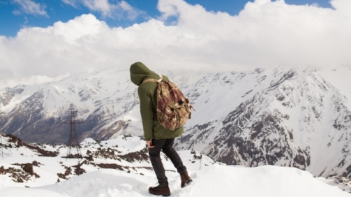 young-hipster-man-hiking-mountains-winter-vacation-traveling_285396-1951